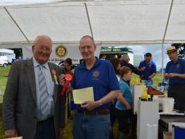 President Peter Farr receives the rosette and certificate for the Best Charity Stall.